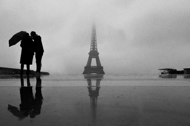 Coppia sotto l’ombrello e la Tour Eiffel nella nebbia